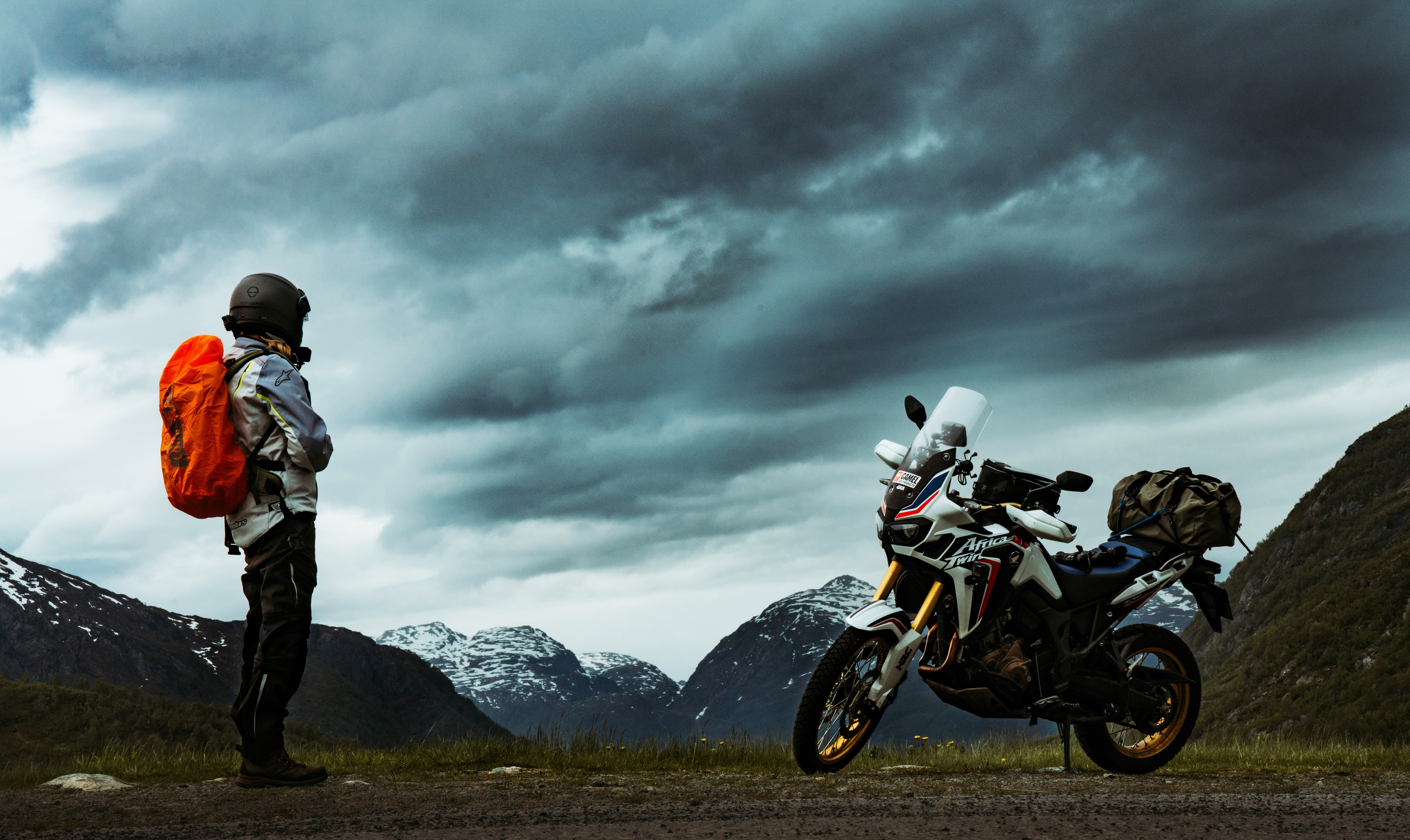 Reise-Enduro und Fahrerin vor Bergpanorama